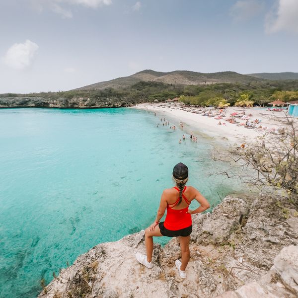 westpunt grote knip strand en een vrouw die op de klip staat