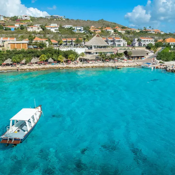 een blauwe zee met een boot op curacao coral estate